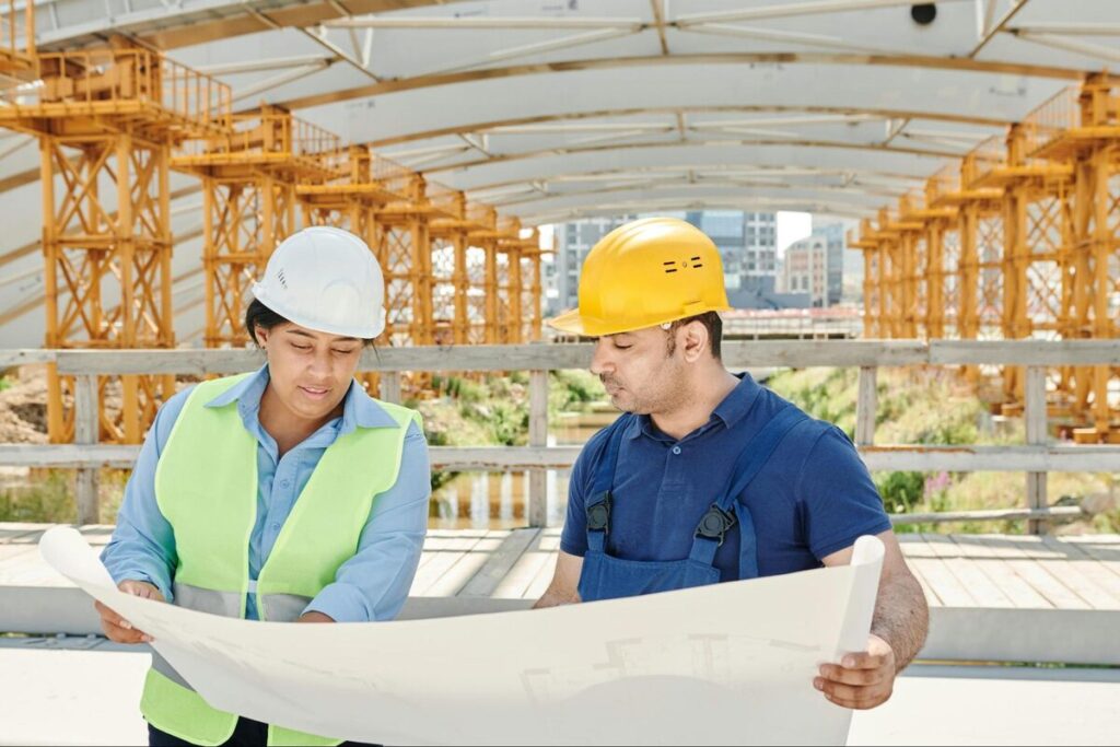 Engineers reviewing blueprints construction site
